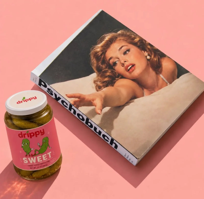 Jar of drippy SWEET pickles next to a vintage pin-up photo book